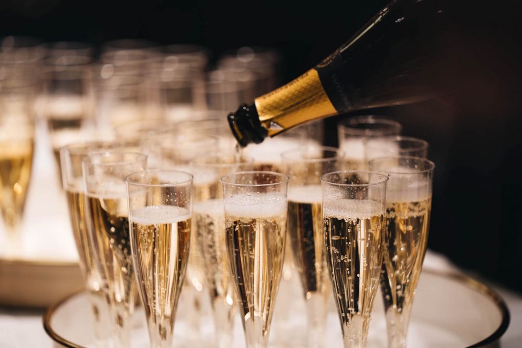champagne glasses being filled from a bar hire package
