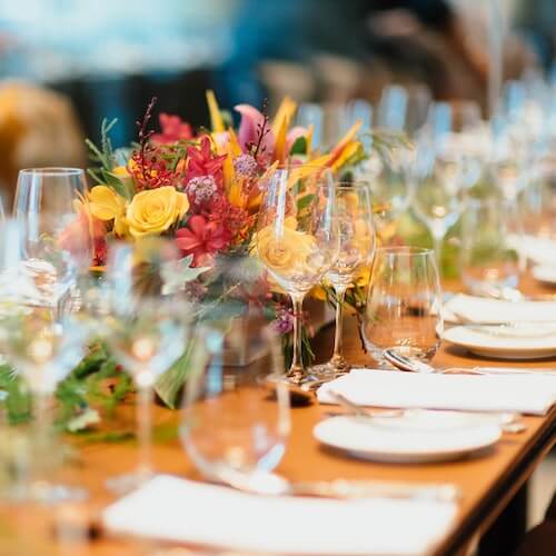 picture of a dressed wedding breakfast table with dried flowers, plates and glasses
