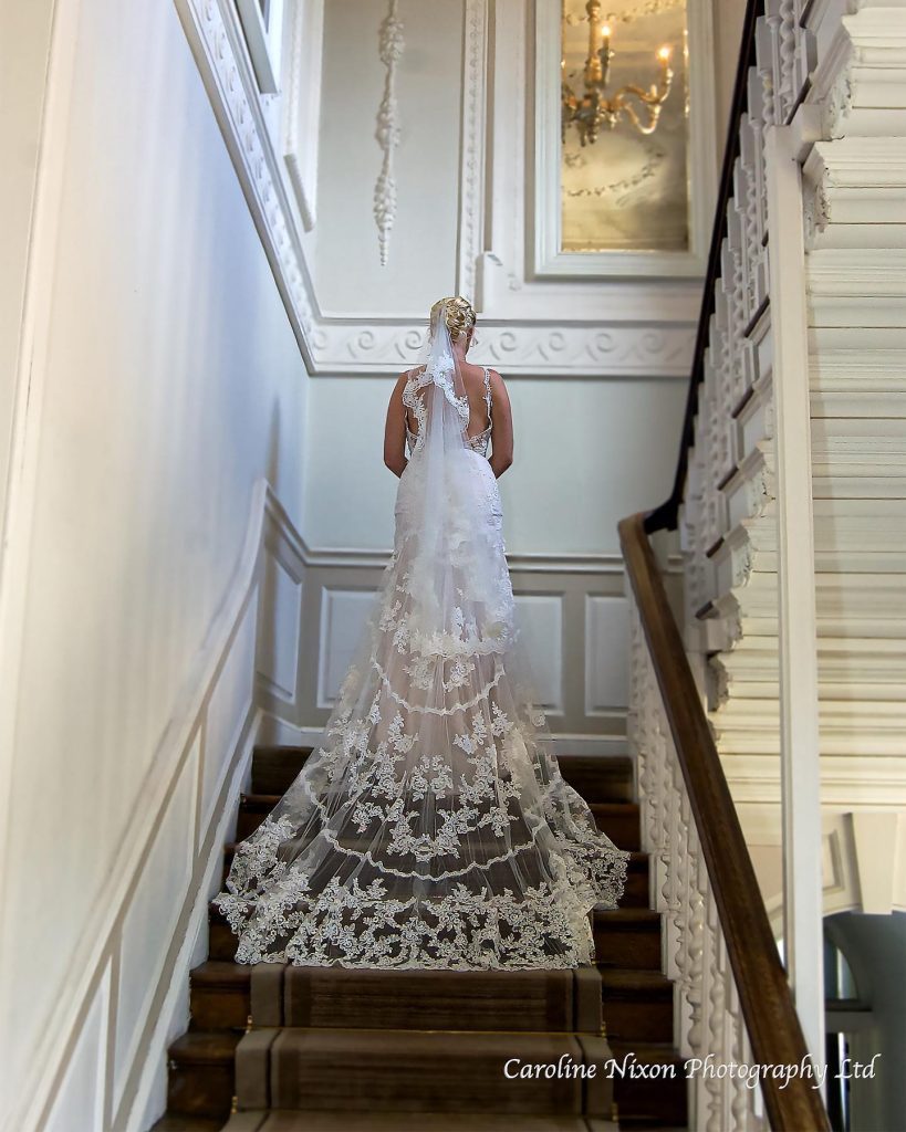 Photogrpahy of bride on a grand stairwell Caroline Nixon Photography