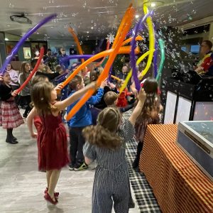 children dancing and waving balloons at a children's entertainer disco party