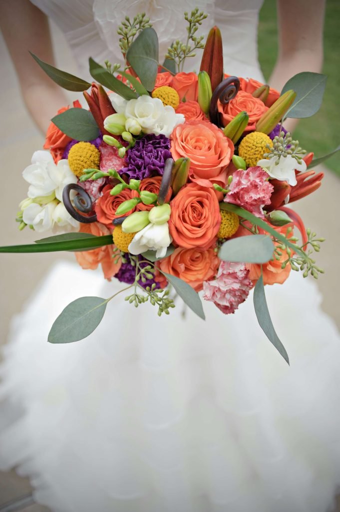 brightly coloured selection of flowers for a bridal bouquet in a brides hands